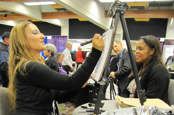 Artist Rasa Natalia sketches a visitor to the CalBar Connect booth in the exhibit hall. <br />
<em>Photo by State Bar of California</em>
