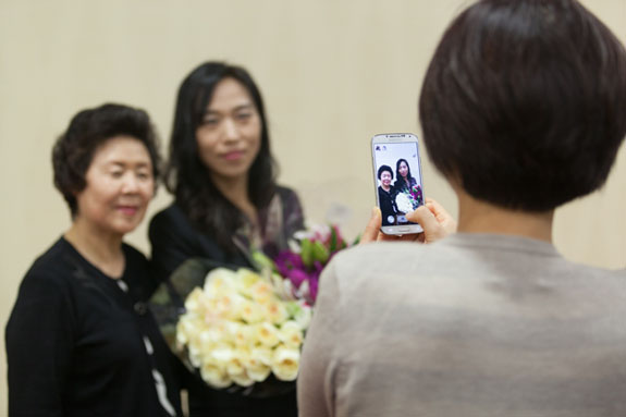 A family member gets an intimate portrait of attorney Youn Lee with her family.   <em>Photo by S. Todd Rogers</em>

